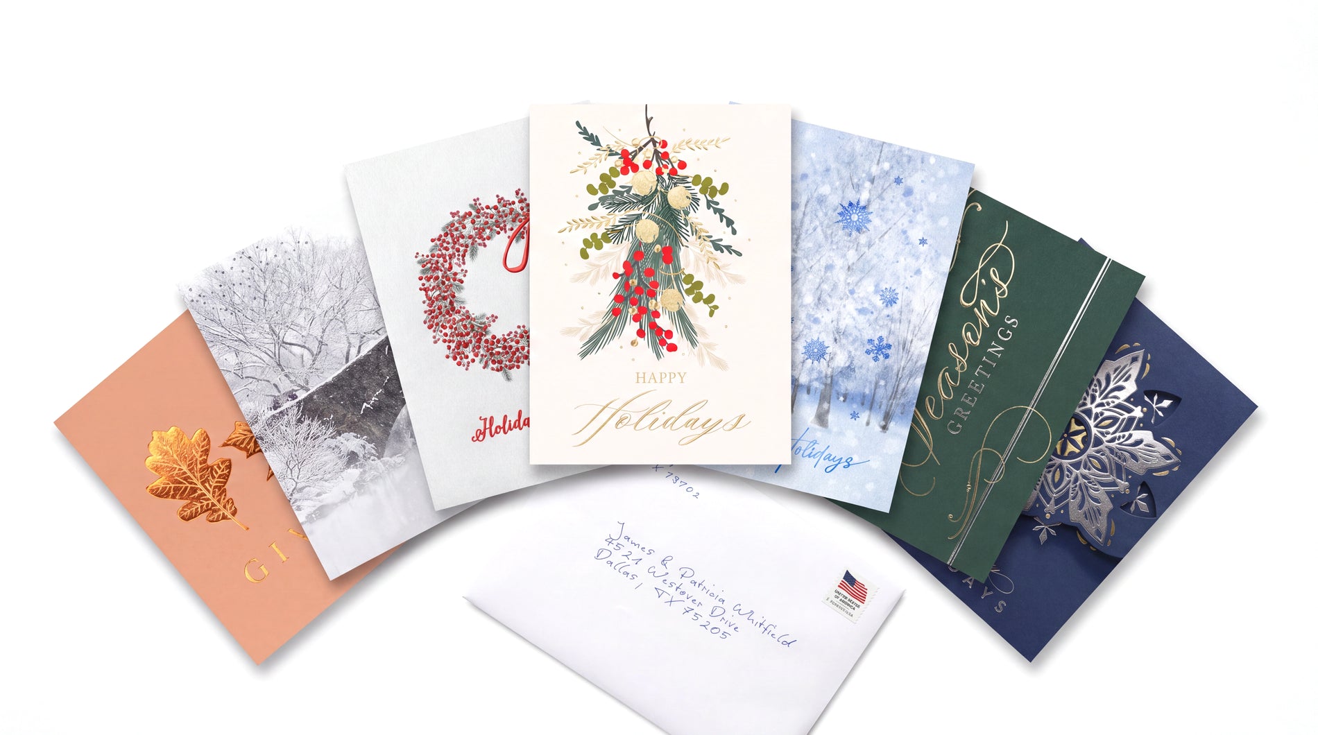 Fanned premium holiday card designs with a handwritten envelope